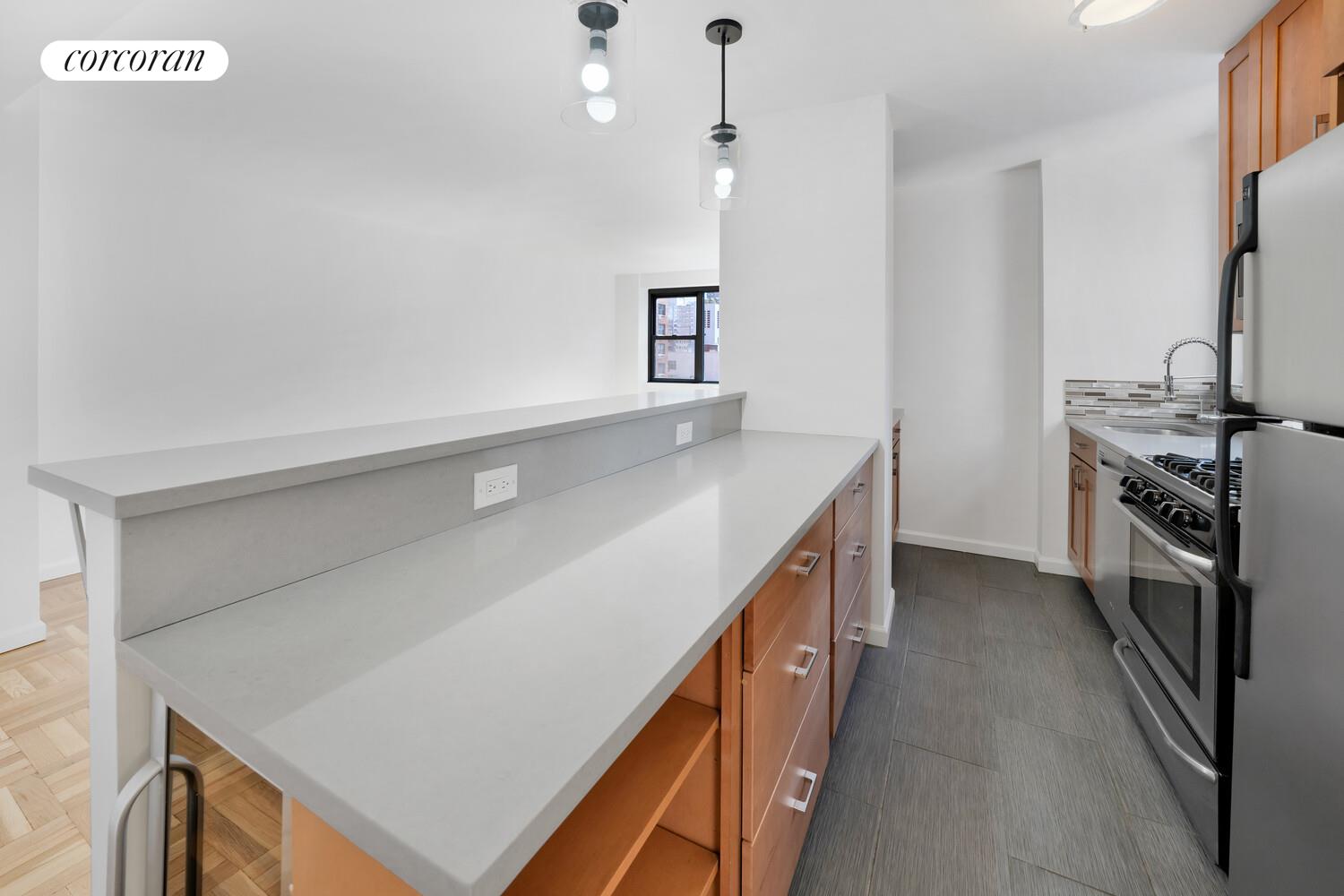 233 East 69th Street, Unit 12K Manhattan, NY 10021 - Photo 7 of 10 a kitchen with a sink a stove and a refrigerator