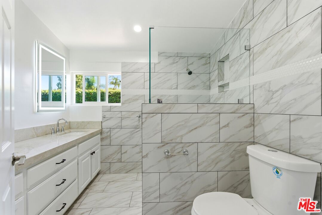 26 Packet Road Rancho Palos Verdes, CA 90275 - Photo 18 of 40 a bathroom with a granite countertop toilet a sink and mirror