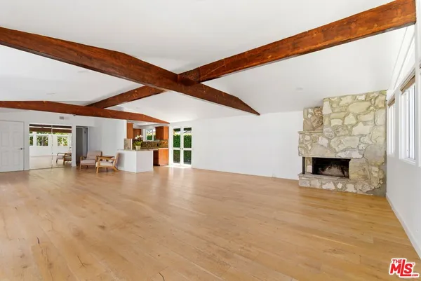 a view of an empty room with window and fireplace