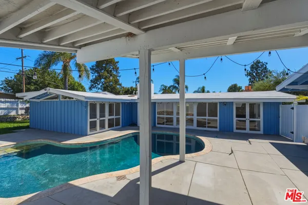 a view of a backyard with table and chairs with wooden fence