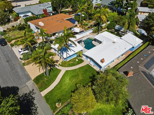 an aerial view of a house with a yard and large tree