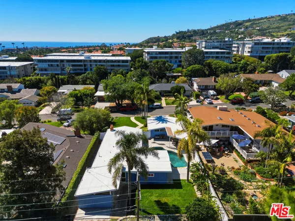 an aerial view of residential house with outdoor space and trees all around