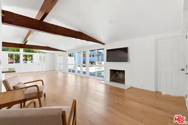 a view of a livingroom with furniture fireplace and wooden floor