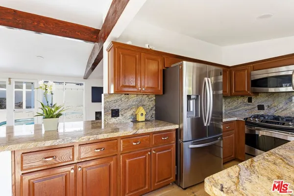 a kitchen with kitchen island granite countertop a large counter top space and stainless steel appliances