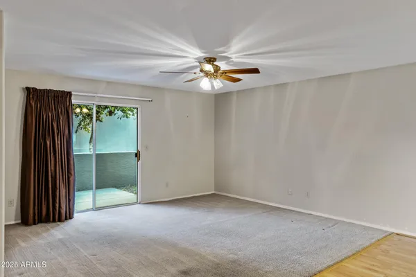 an empty room with closet and fan