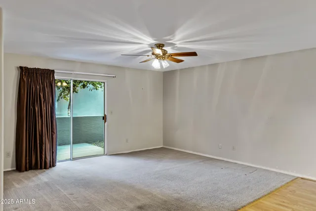an empty room with closet and fan