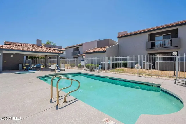 a view of a house with a swimming pool and sitting area