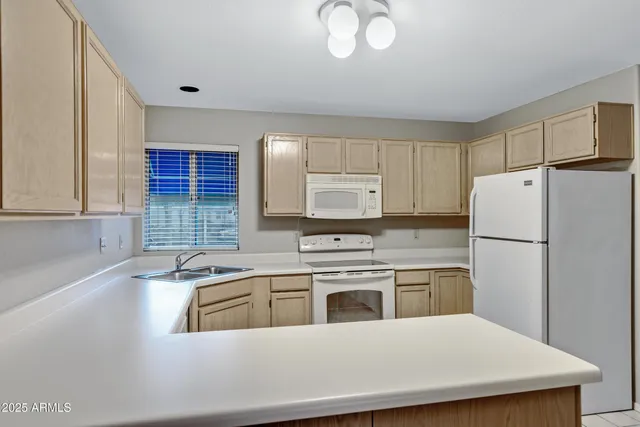 a kitchen with stainless steel appliances a refrigerator a sink a stove and white cabinets