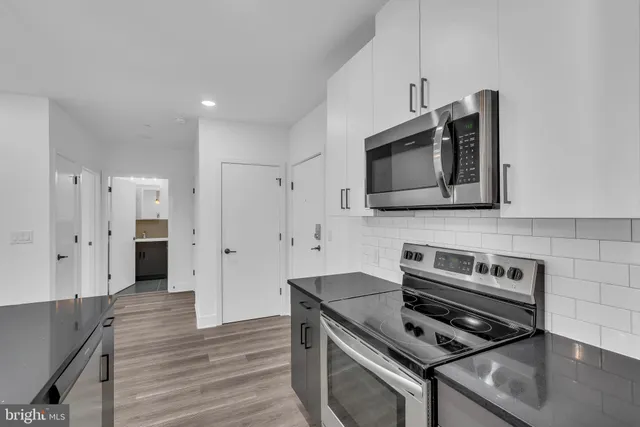 a kitchen with stainless steel appliances a stove a microwave and a refrigerator