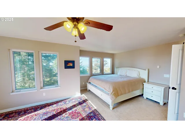a bedroom with a bed lamp and a large window