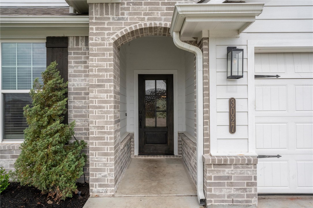3027 Wolfpack Loop Bryan, TX 77808 - Photo 2 of 39 a front view of a house with a garden