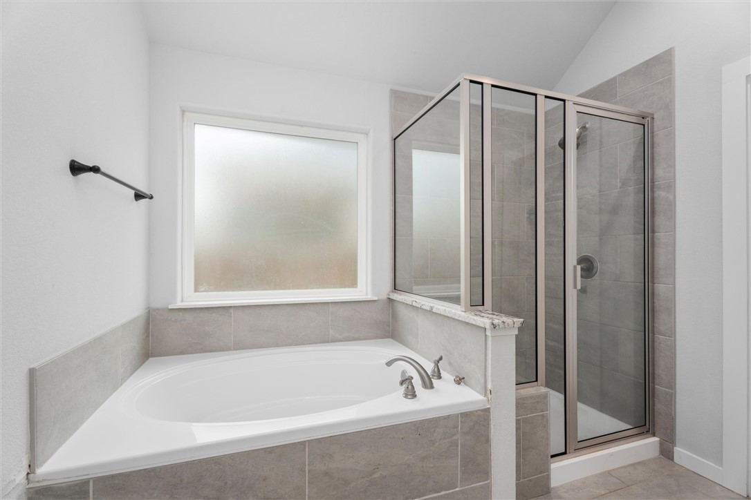 3027 Wolfpack Loop Bryan, TX 77808 - Photo 25 of 39 a bathroom with a bath tub and a shower