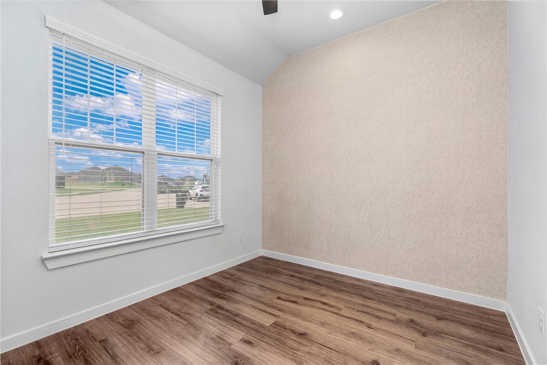 3027 Wolfpack Loop Bryan, TX 77808 - Photo 6 of 39 an empty room with wooden floor and windows