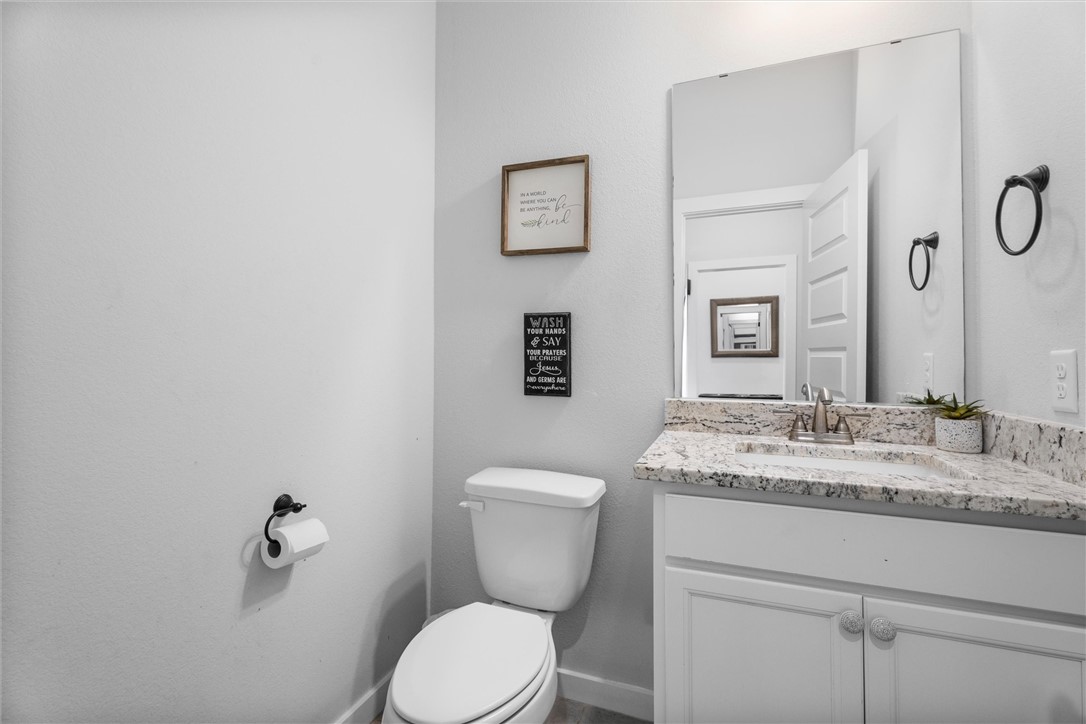 3027 Wolfpack Loop Bryan, TX 77808 - Photo 8 of 39 a bathroom with a granite countertop toilet sink and mirror