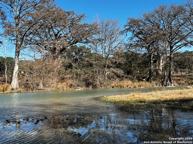 235 Madrone Concan, TX 78838 - Photo 8 of 11 a view of a lake with a yard