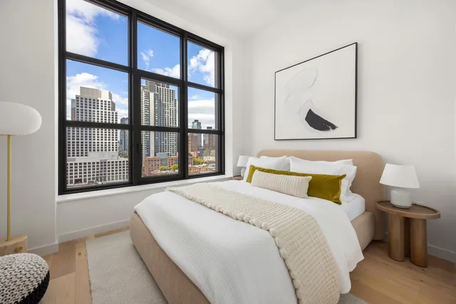 a spacious bedroom with a bed and a large window