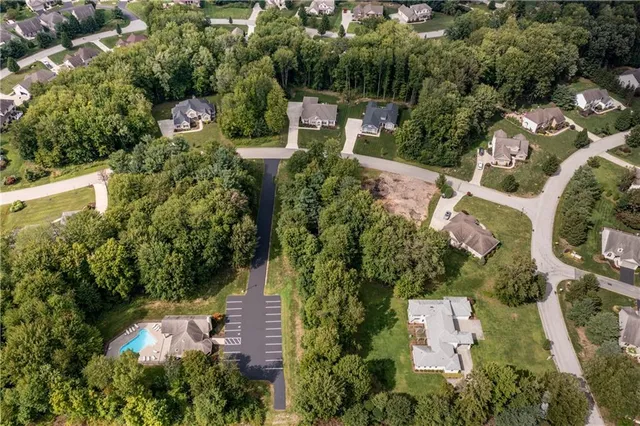 an aerial view of residential house with outdoor space and trees all around