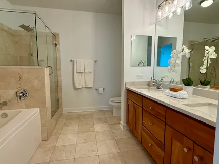 a spacious bathroom with a tub sink shower and mirror