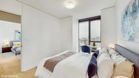 a bedroom with a bed and a large window