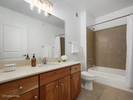 a bathroom with a double vanity sink toilet mirror and shower