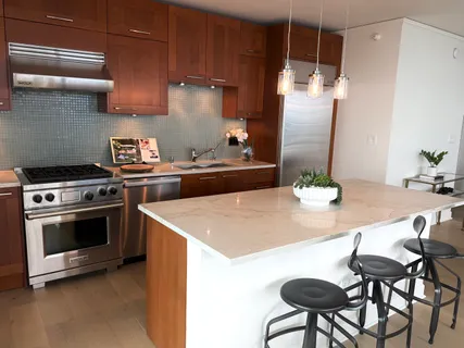 a kitchen with stainless steel appliances a table chairs and stove