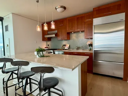 a kitchen with stainless steel appliances granite countertop a sink a stove and a refrigerator