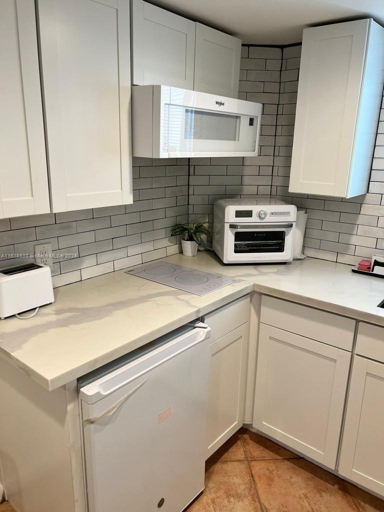 820 3rd Street, Unit 3 Miami Beach, FL 33139 - Photo 18 of 24 a kitchen with a sink and a stove top oven