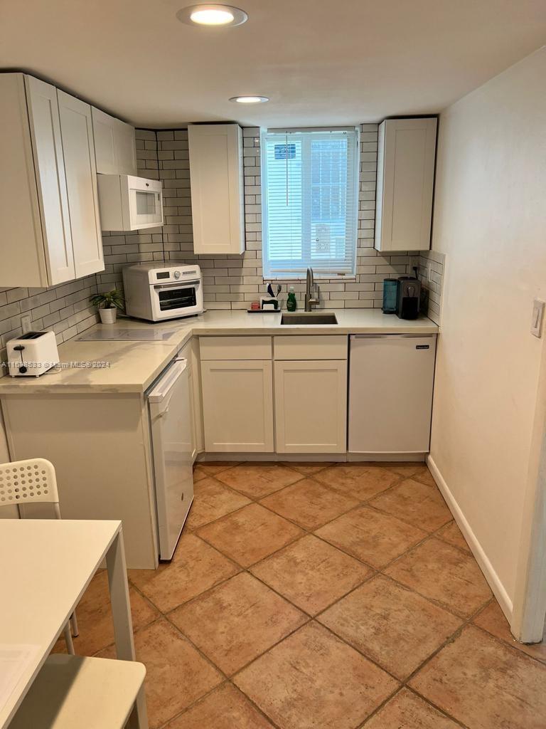 820 3rd Street, Unit 3 Miami Beach, FL 33139 - Photo 19 of 24 a kitchen with a sink a stove and cabinets