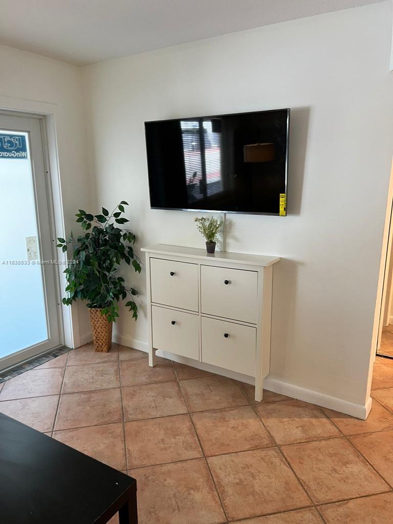 820 3rd Street, Unit 3 Miami Beach, FL 33139 - Photo 7 of 24 a living room with a potted plant a sink and a mirror