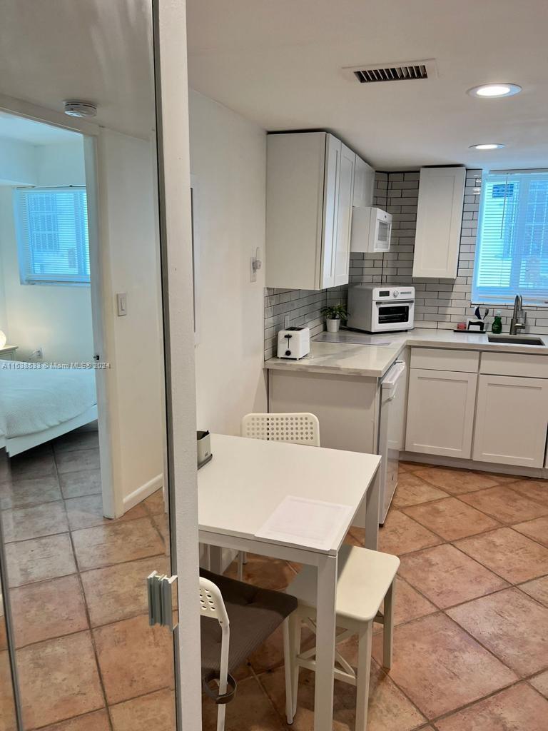 820 3rd Street, Unit 3 Miami Beach, FL 33139 - Photo 10 of 24 a kitchen with stainless steel appliances kitchen island granite countertop a sink and cabinets