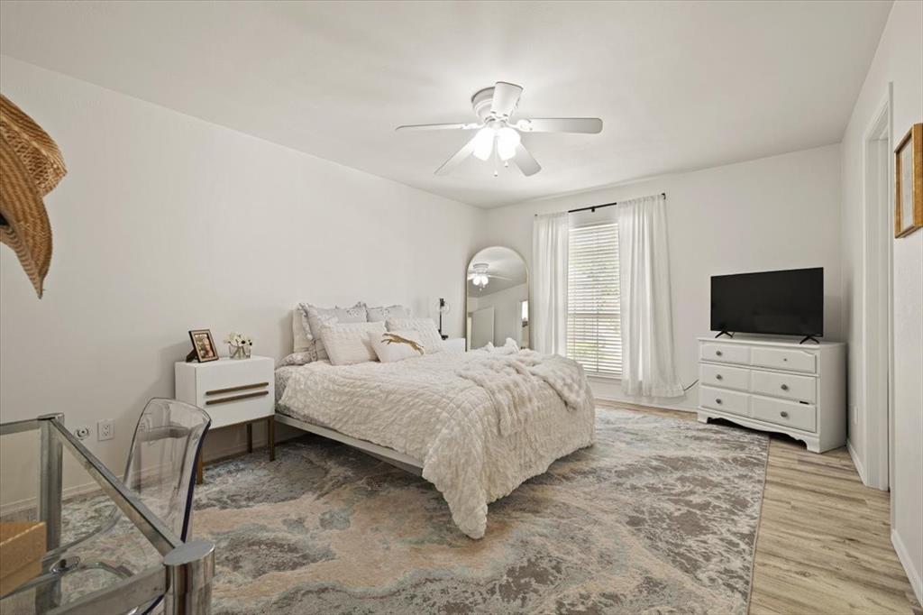 4100 Ridglea Country Club Drive, Unit 1401 Fort Worth, TX 76126 - Photo 21 of 27 a spacious bedroom with a bed and a flat screen tv