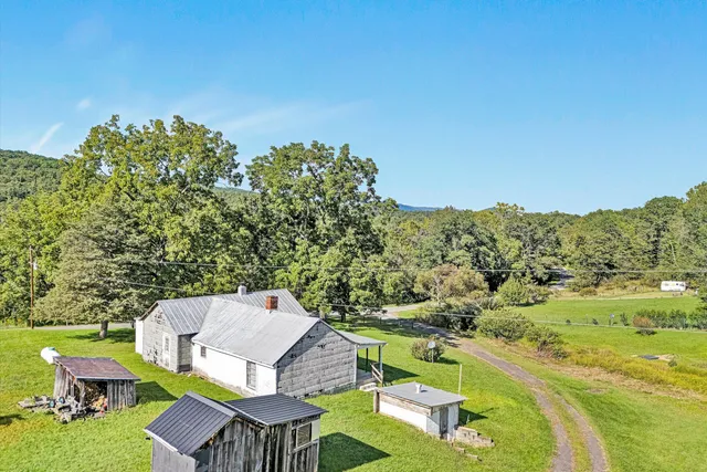 a view of a house with backyard and a tree