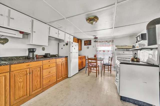 a kitchen with a stove a refrigerator and a table