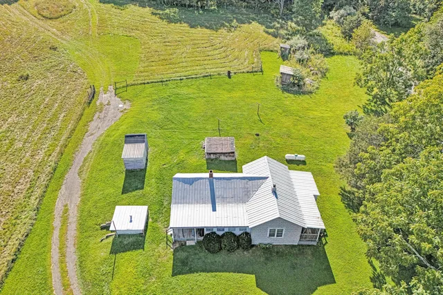 a aerial view of a house with a yard table and chairs