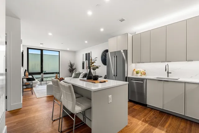 a kitchen with stainless steel appliances kitchen island granite countertop a sink stove and refrigerator