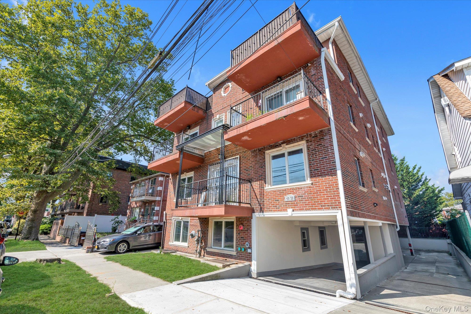 40-38 194th Street, Unit A1 Queens, NY 11358 - Photo 1 of 18 a front view of a residential apartment building with a yard