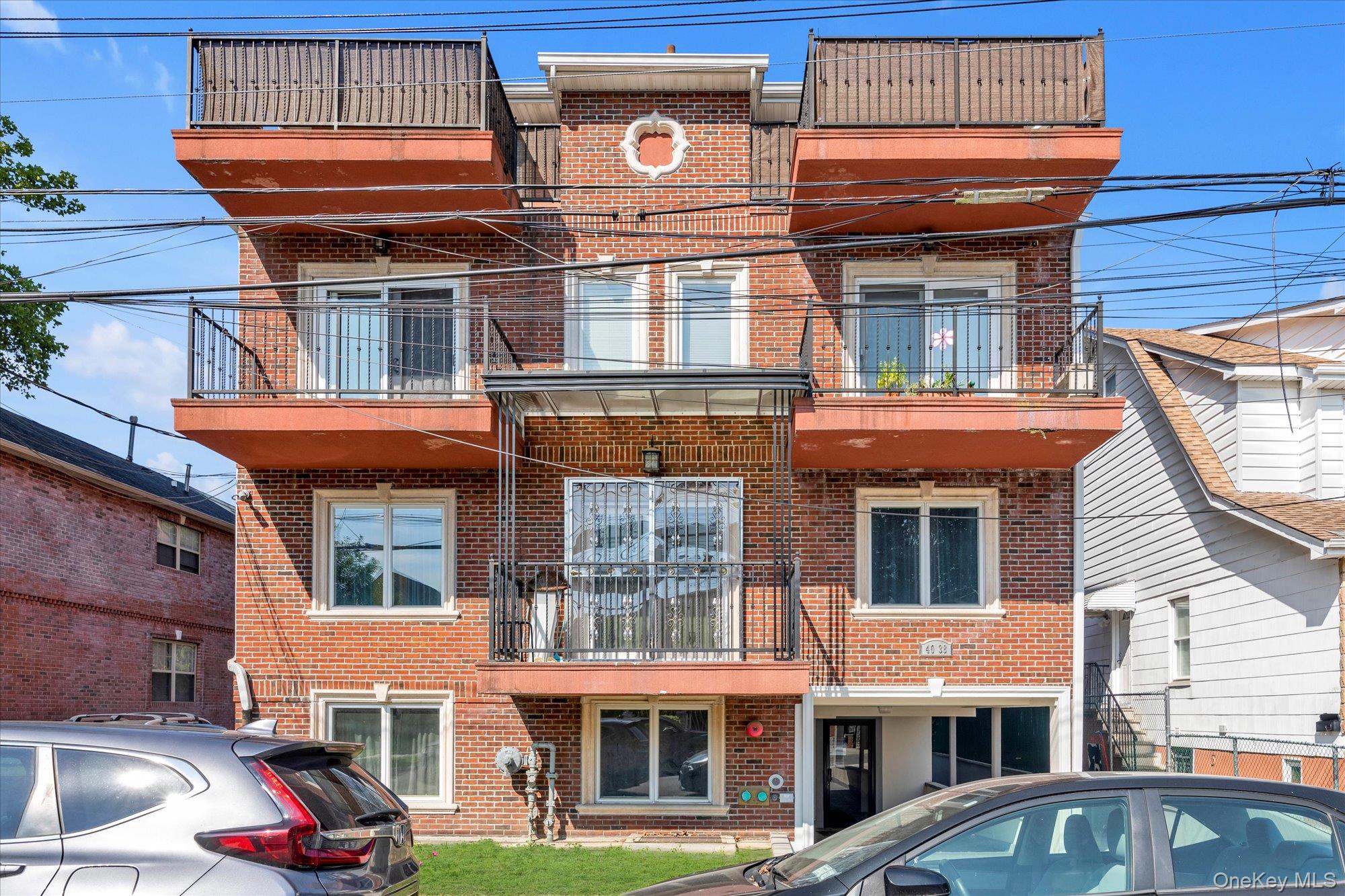 40-38 194th Street, Unit A1 Queens, NY 11358 - Photo 2 of 18 a front view of a residential apartment building with a yard