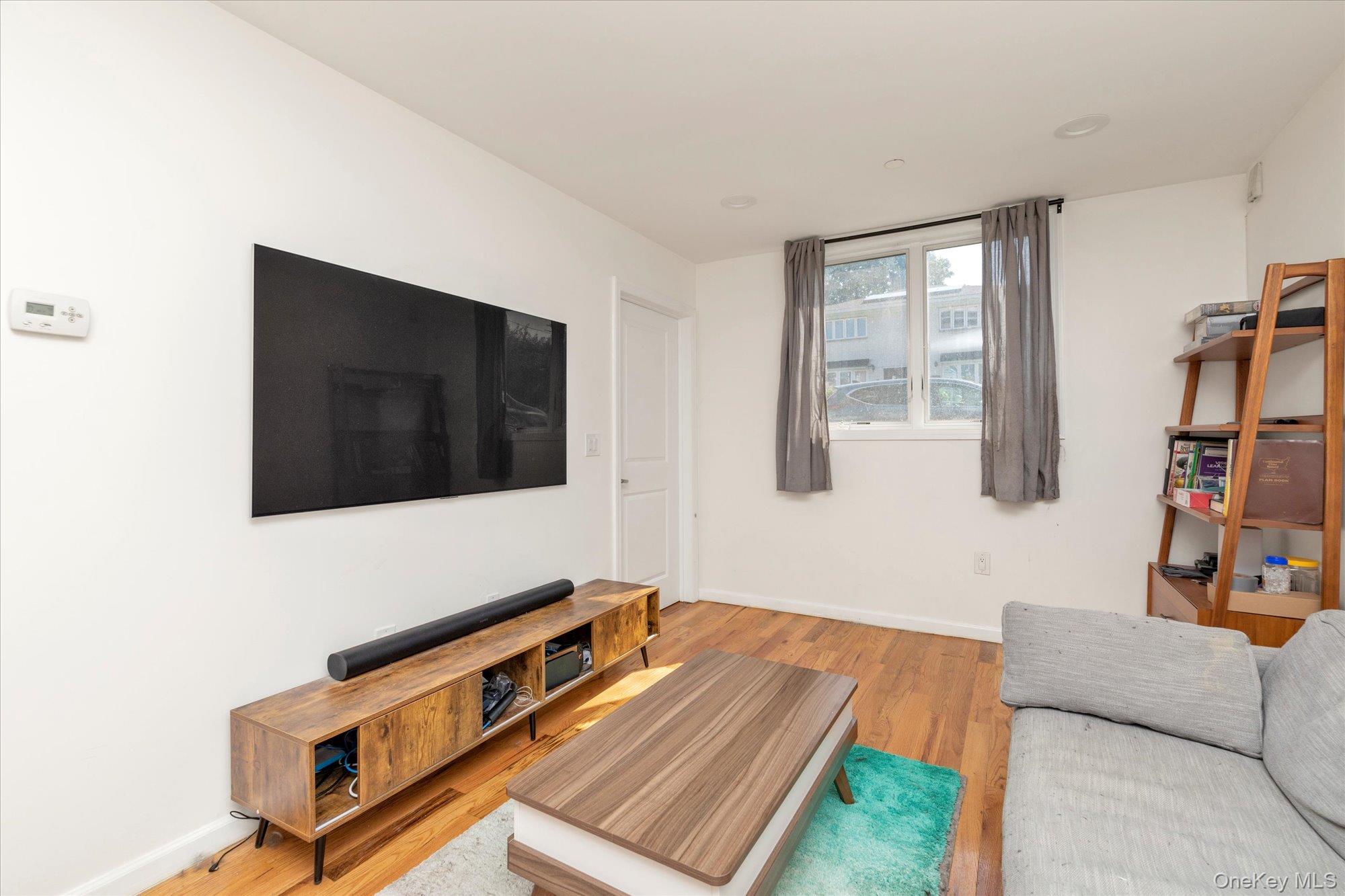 40-38 194th Street, Unit A1 Queens, NY 11358 - Photo 5 of 18 a living room with furniture and a flat screen tv