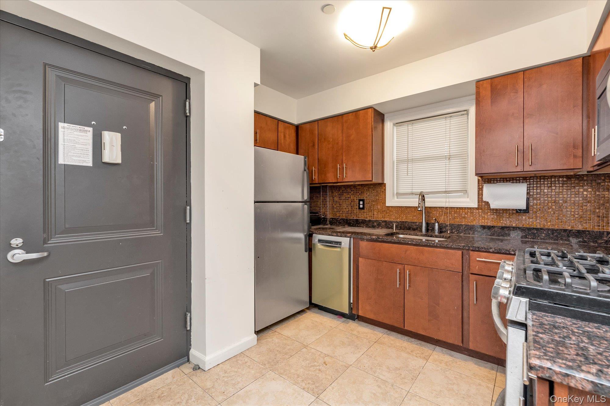 40-38 194th Street, Unit A1 Queens, NY 11358 - Photo 9 of 18 a kitchen with stainless steel appliances granite countertop a refrigerator and a stove top oven