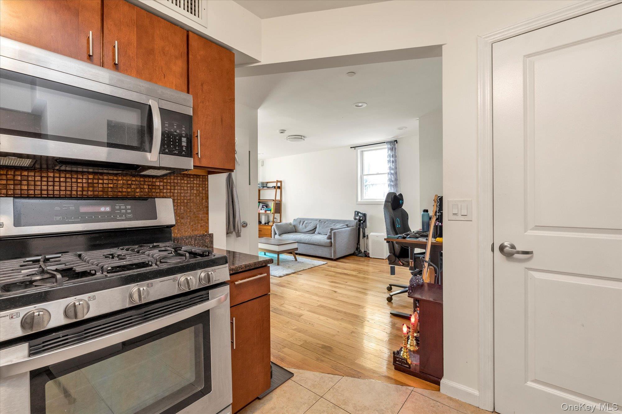 40-38 194th Street, Unit A1 Queens, NY 11358 - Photo 10 of 18 a kitchen with stainless steel appliances a stove a microwave and a counter top space