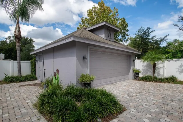 a view of a house with a yard plants and palm trees