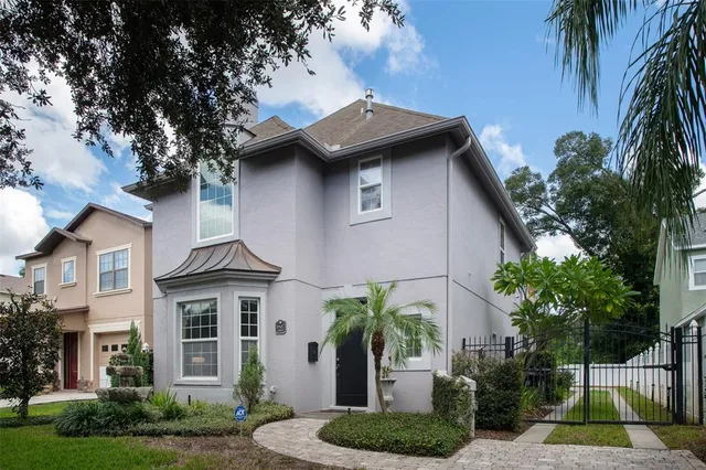 a view of a house with a yard plants and palm trees