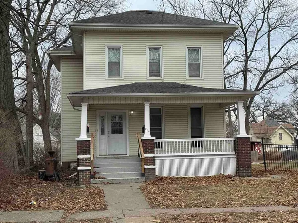 a front view of a house with a tree