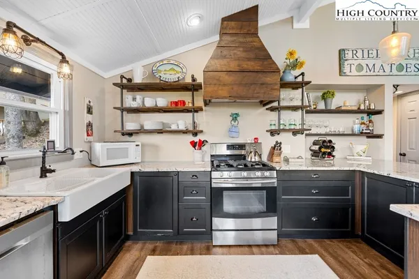 a kitchen with stainless steel appliances granite countertop a stove and cabinets