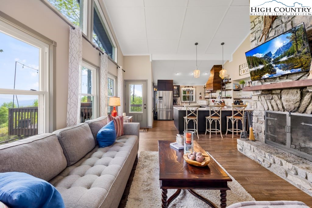844 Pine Ridge Road Beech Mountain, NC 28604 - Photo 14 of 34 a living room with furniture a flat screen tv and a floor to ceiling window