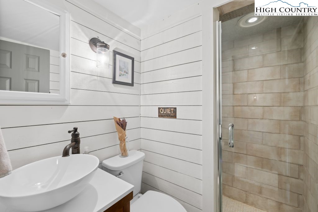 844 Pine Ridge Road Beech Mountain, NC 28604 - Photo 17 of 34 a bathroom with a sink a toilet and mirror