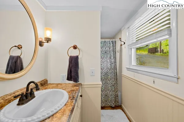 a bathroom with a sink a toilet and a mirror