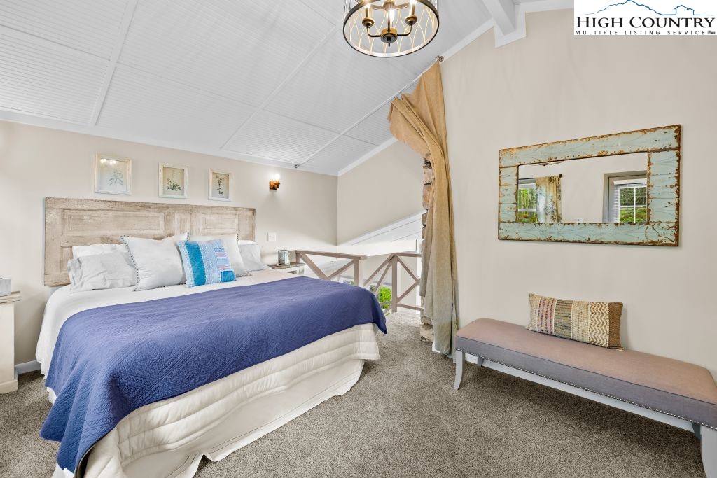 844 Pine Ridge Road Beech Mountain, NC 28604 - Photo 21 of 34 a bedroom with a bed and a chandelier