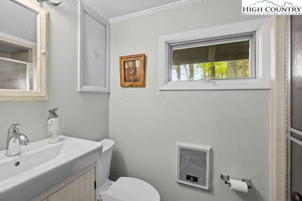a bathroom with a toilet sink vanity and mirror
