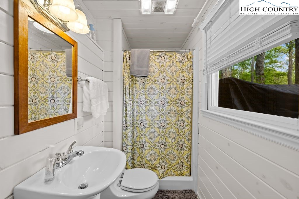 844 Pine Ridge Road Beech Mountain, NC 28604 - Photo 25 of 34 a bathroom with a sink a toilet a mirror and shower